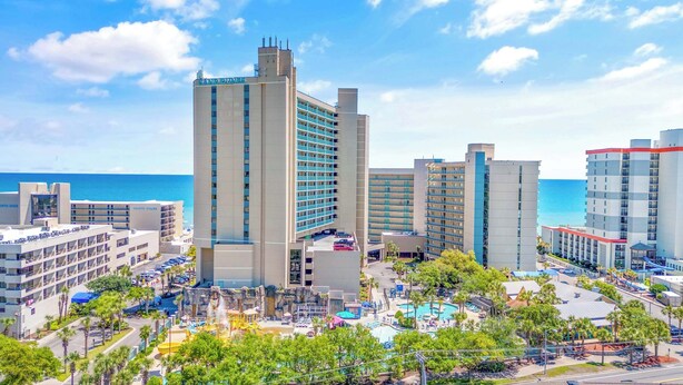 A hotel with multiple floors, a pool area, and a view of the ocean. - Paradise Ocean View at Sand Dunes Resort (Myrtle Beach)