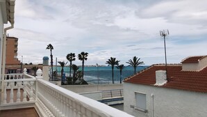 Un balcón con vista al mar y palmeras.