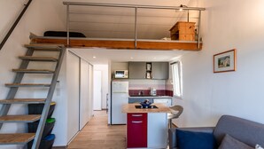 A compact living space with a loft bedroom, a kitchenette, and a seating area. - Ambroggio - Grand studio avec mezzanine - Vue Mer (Lumio)