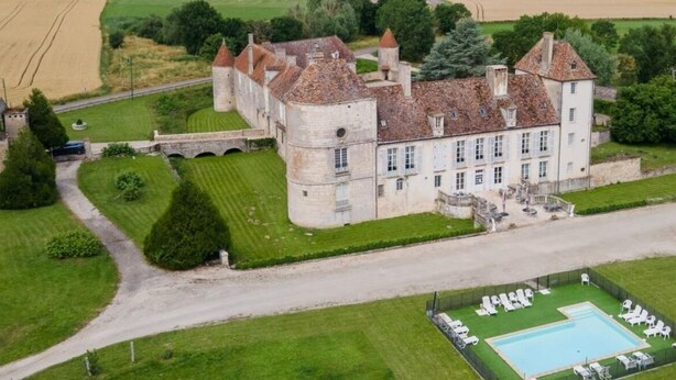 A large, historic building with a courtyard and a swimming pool.