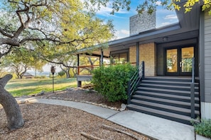 Stunning entrance with a grand staircase and beautifully landscaped garden.