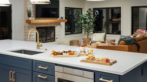 A modern kitchen with a large island, built-in appliances, and a fireplace.