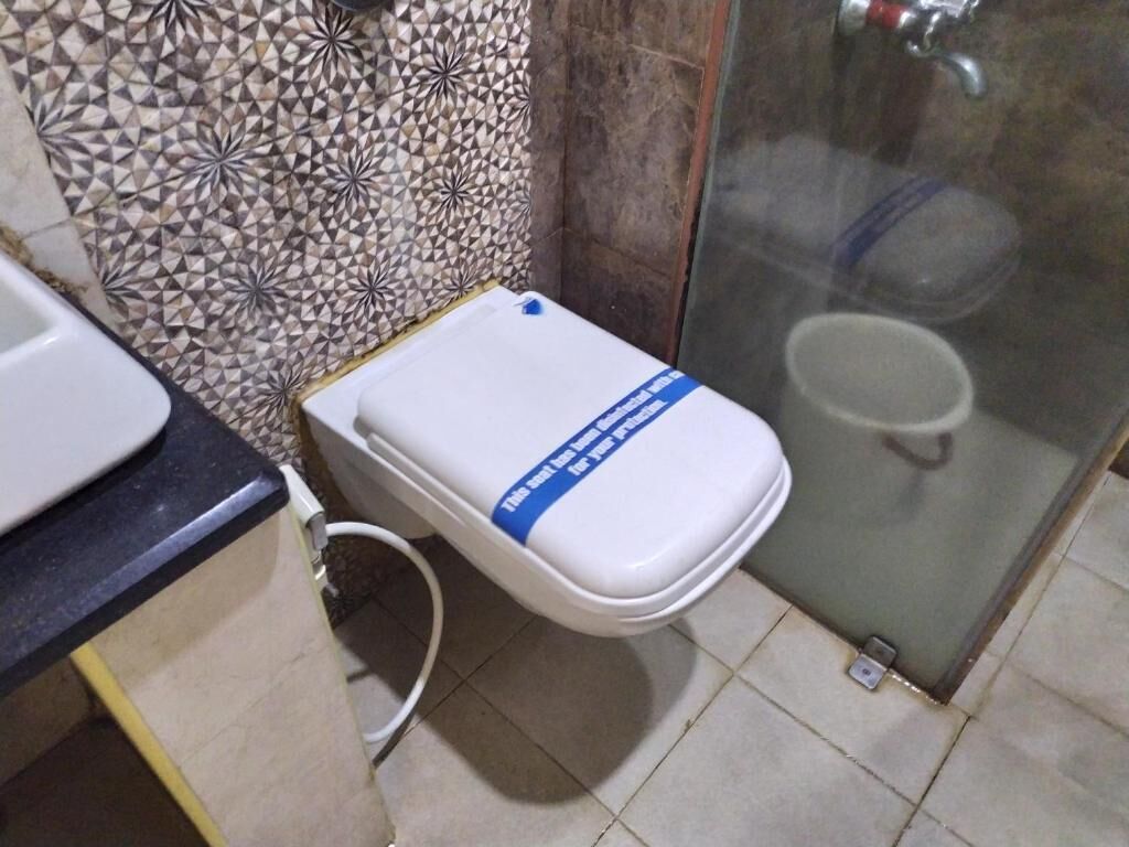 A bathroom with a toilet, a shower, and a sink.