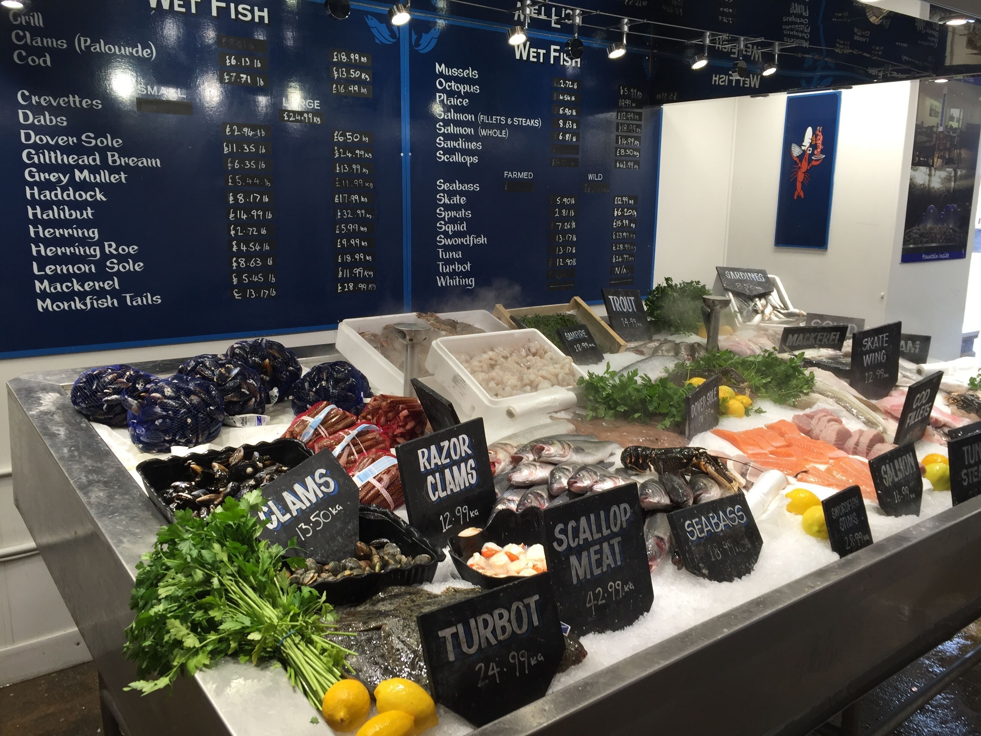 A seafood display with various types of fish and seafood, including labels for prices and weights.