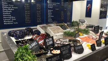 A seafood display with various types of fish and seafood, including labels for prices and weights.