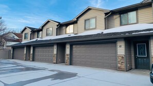 A row of townhouses with attached garages, numbered 8 to 10, under a clear sky. - Juniper Townhouse #4 (Mitchell)
