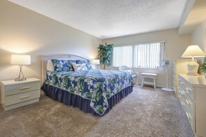 A bedroom with a bed, bedside tables, a desk, and a chair.