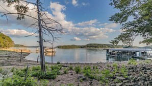 A lakeside view with a dock extending into the water, surrounded by rocky terrain and sparse vegetation. - LAKE ARCADE - 5bd 4bth, FAMILY FUN SPOT, 3 stories (Garfield)