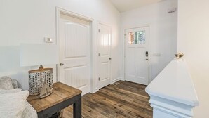 A room with a wooden table, a lamp, and a white door with a window. - LAKE ARCADE - 5bd 4bth, FAMILY FUN SPOT, 3 stories (Garfield)