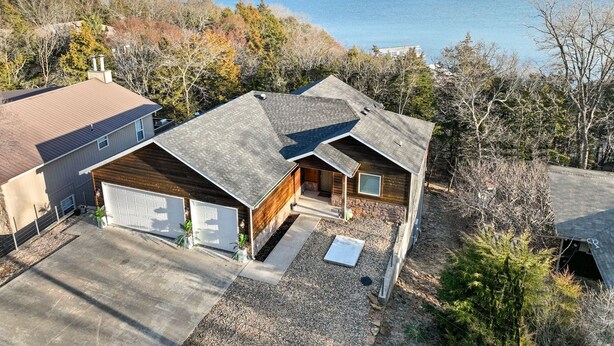 A two-story house with a garage, a covered porch, and a view of a lake. - LAKE ARCADE - 5bd 4bth, FAMILY FUN SPOT, 3 stories (Garfield)