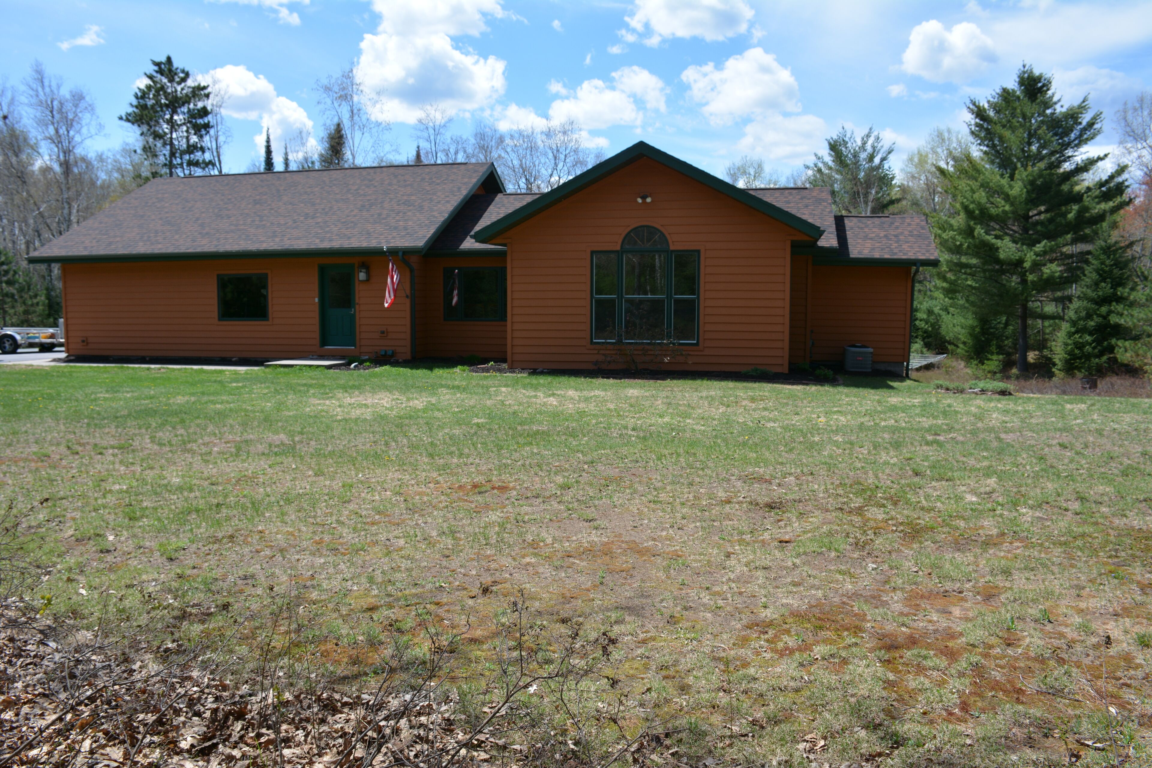A single-story wooden house with a gabled roof, a front porch, and a small front yard.
