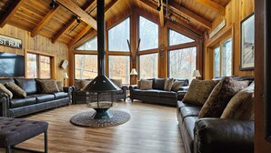Ein gemütliches Wohnzimmer mit Ledersofas, einem Couchtisch in der Mitte und einem Kamin.