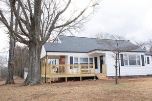Stunning single-story home with a charming front porch and lush surroundings.
