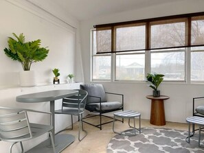 Enjoy a comfortable stay in this stylish room with a large window offering a view, a dining area, and a cozy seating space.