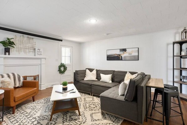 Uma sala de estar moderna com sofá modular, mesa de centro e estante.