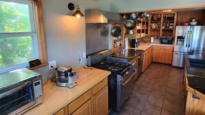 A kitchen with wooden cabinets, a stainless steel refrigerator, a stove, and a coffee maker. - Dog Friendly and Beautiful Main Channel View at the 34.5MM in a "NO WAKE" cove.. (Sunrise Beach)