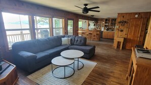 A cozy living room with a sectional sofa, two round coffee tables, and a wooden floor. - Dog Friendly and Beautiful Main Channel View at the 34.5MM in a "NO WAKE" cove.. (Sunrise Beach)