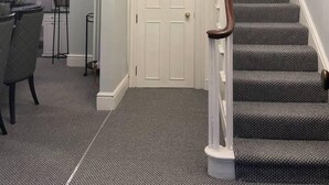 A staircase with a white handrail and grey carpeted steps, leading to a door. - 5 Bed House - Sleeps 12 - Pets - Parking (Ross-on-Wye)