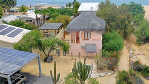 A coastal property with a house featuring a thatched roof, solar panels, and a view of the sea. - Aqua Ventana (El Sargento)