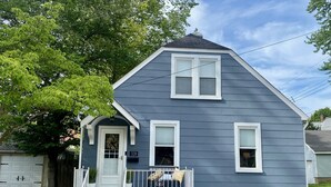 A two-story house with a gray exterior, white trim, and a front porch with a small railing. - Walk to St Charles Main St. Shops, Eateries & Bars! (Saint Charles)