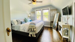 A bedroom with a bed, a ceiling fan, a TV, a window, and a bedside table. - Walk to St Charles Main St. Shops, Eateries & Bars! (Saint Charles)