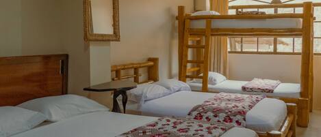 Habitación de hotel con tres camas, una litera de madera, una mesita, un espejo y una ventana con cortinas.