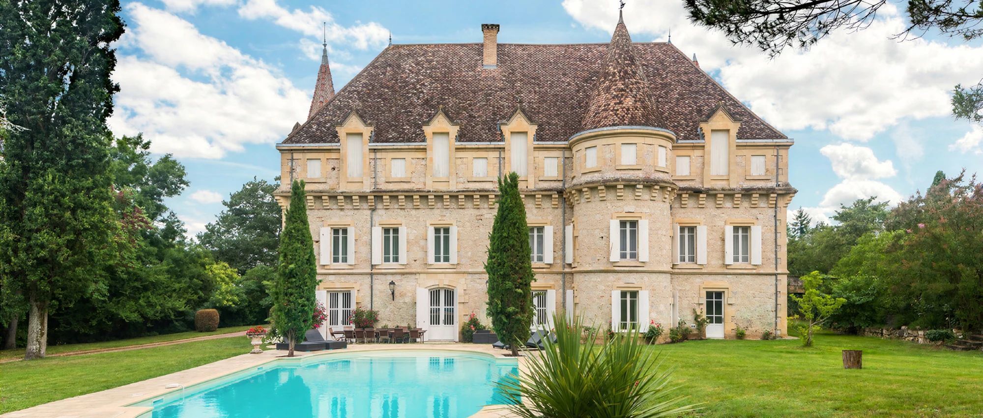 Un grand bâtiment historique avec une piscine située devant.