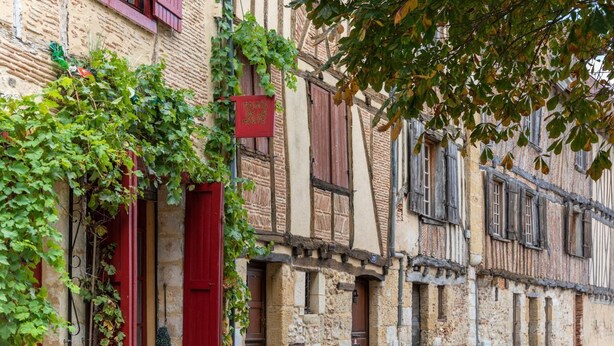 A row of traditional stone buildings with wooden shutters and a cobblestone street. - Villa Du Fleuve - Four Bedroom Villa, Sleeps 8 (Flaujagues)