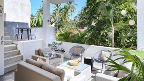 A modern outdoor living area with a sofa, chairs, and a coffee table.