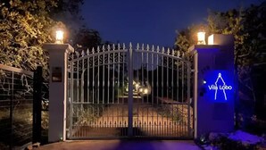 Una entrada protegida por un muro con un cartel que dice "Villa Lobo".