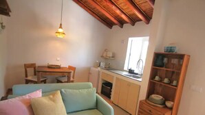 Una sala de estar acogedora con un sofá, una mesa de comedor y una zona de cocina.