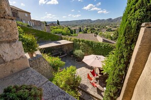A courtyard with stone walls, potted plants, and outdoor furniture. - Les Alpilles - Six Bedroom Villa, Sleeps 10 (Eygalières)