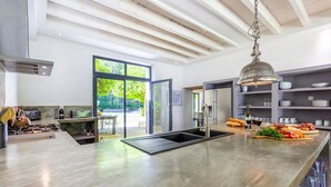 A modern kitchen with a large island, stainless steel appliances, and a view of the outdoors. - Le Vieux Moulin - Seven Bedroom Villa, Sleeps 14 (Saint-Avit-Sénieur)