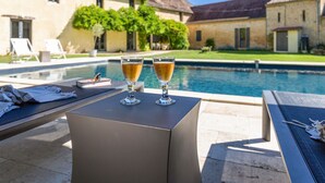 A poolside area with lounge chairs and two glasses of a beverage on a table. - Le Vieux Moulin - Seven Bedroom Villa, Sleeps 14 (Saint-Avit-Sénieur)