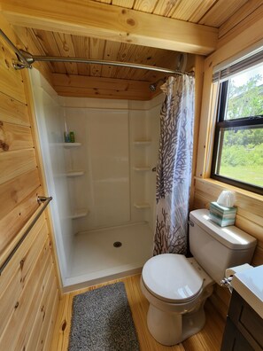 Bañera con ducha, toallas, jabón, shampoo