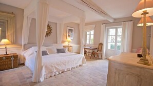 Une chambre à coucher avec un lit à baldaquin, une table en bois et une chaise.