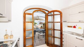 A kitchen with a wooden-framed door leading to an outdoor patio area.