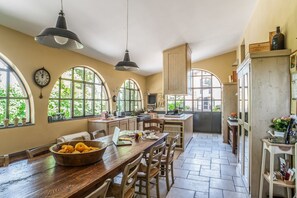 A spacious kitchen with large windows, wooden furniture, and a variety of appliances. - Villa Fratini - Six Bedroom Villa, Sleeps 12 (Terranuova Bracciolini)