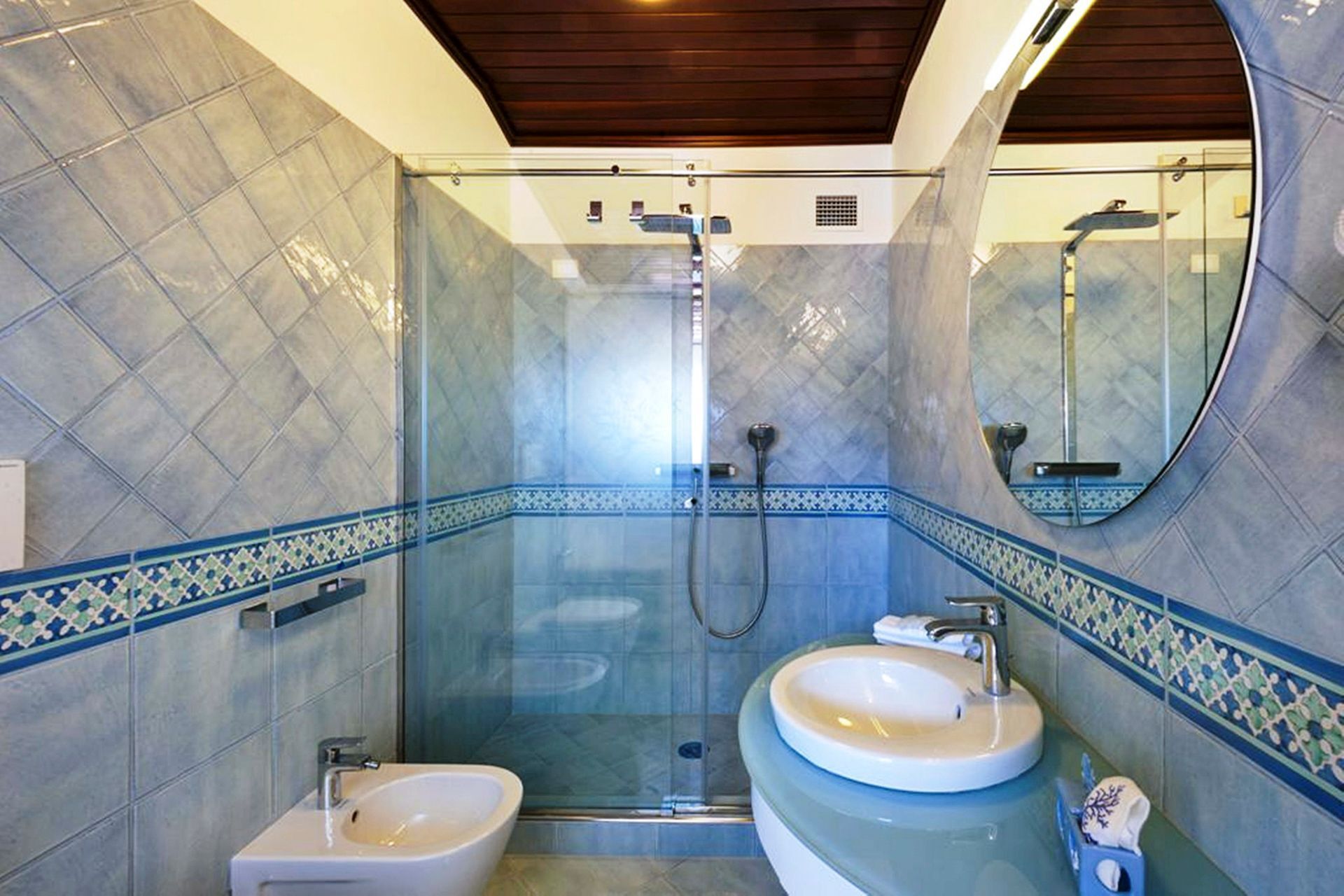 A bathroom with two sinks, a shower, and a mirror.