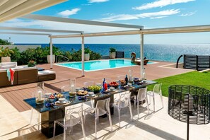 A covered outdoor dining area with a pool and ocean view. - Villa Incanto - Four Bedroom Villa, Sleeps 8 (Plemmirio)