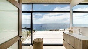 A modern bathroom with a large window, a sink, and a wicker basket. - Villa Incanto - Four Bedroom Villa, Sleeps 8 (Plemmirio)