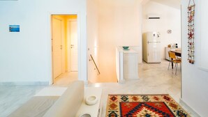 Een modern appartement met een keuken, een eethoek en een gang naar een badkamer.