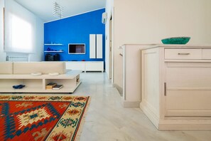 Een moderne woonkamer met een bank, een bijzettafeltje en een kamerkleed met een patroon.
