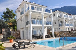 Un immeuble de deux étages doté de balcons, d’une piscine et de mobilier d’extérieur.
