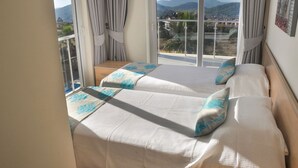 A bedroom with two beds, a balcony, and a view of the landscape. - Villa Gunes - Three Bedroom Villa, Sleeps 6 (Ölüdeniz Belediyesi)