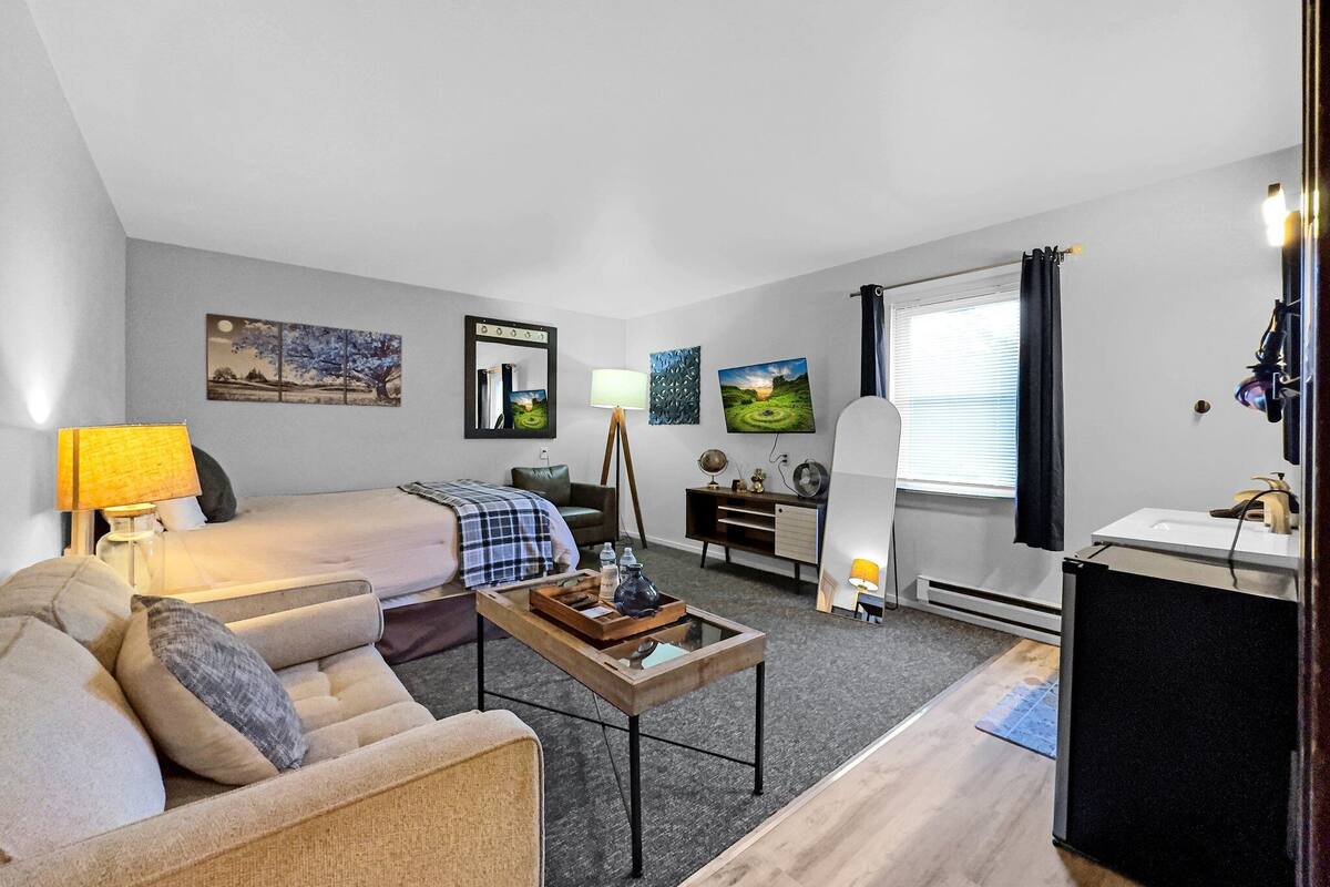 A modern living room with a sofa, a coffee table, a TV, and artwork on the walls.