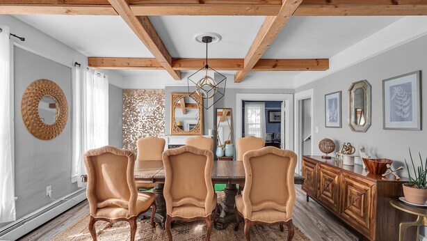 A dining area with a wooden ceiling, a round mirror, and wicker chairs. - Timberline Lodge (Ellicottville)
