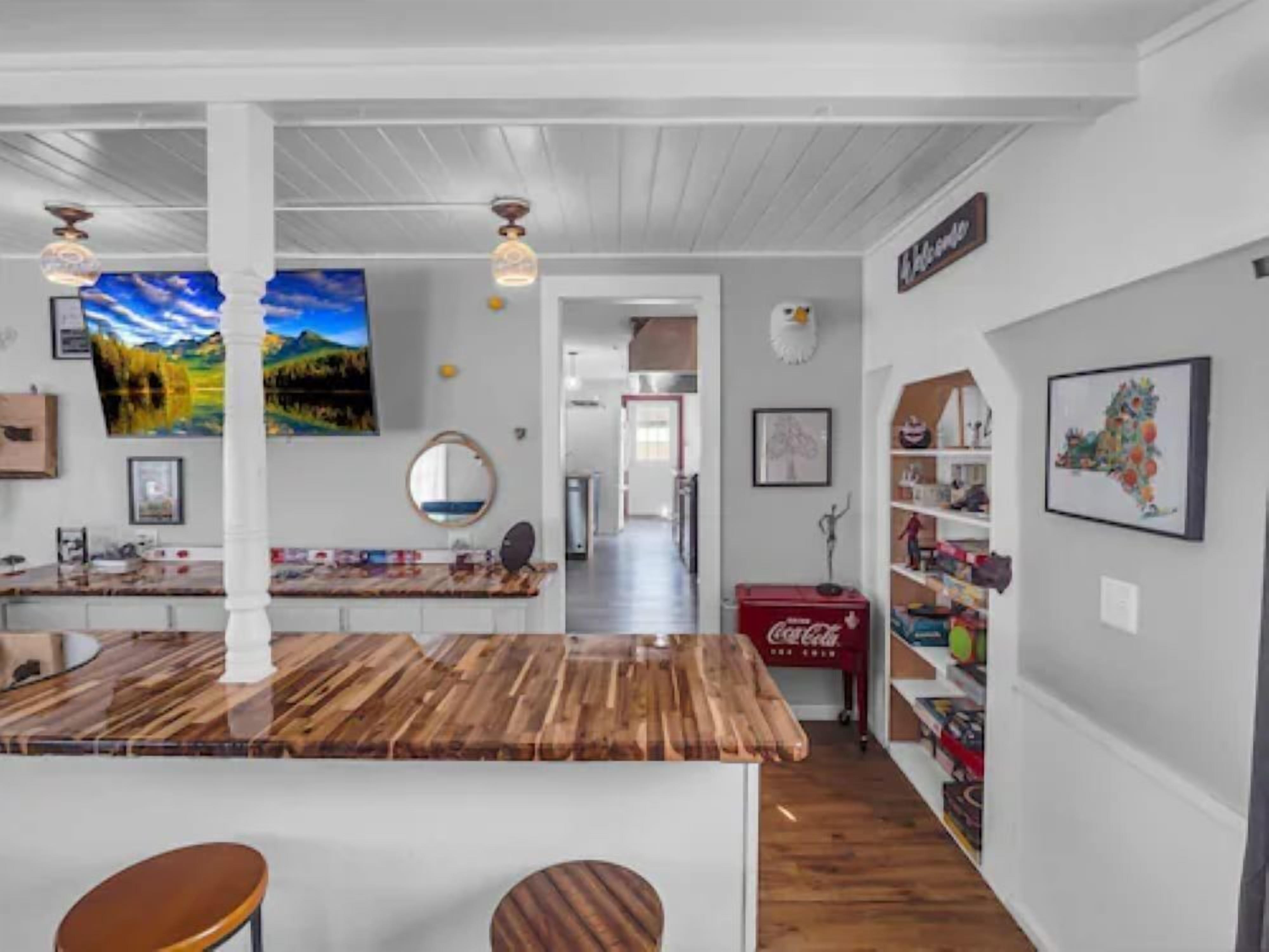 A kitchen with a wooden island, white cabinetry, and a red Coca-Cola cooler.