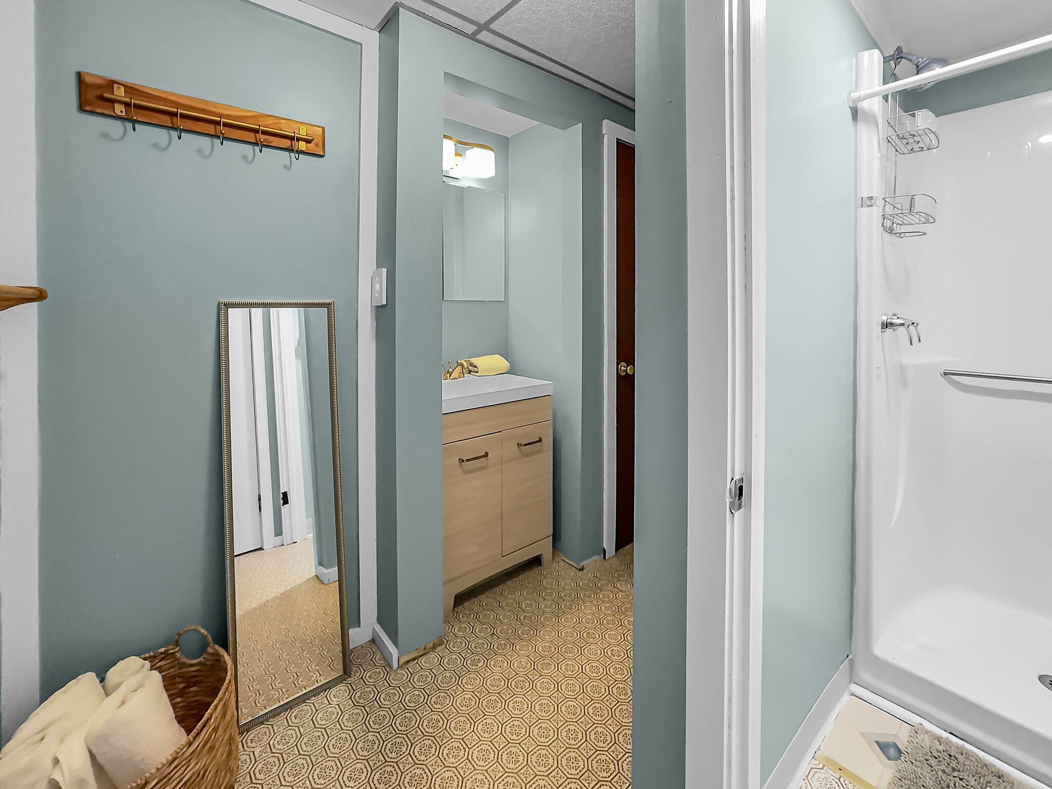 A bathroom with a shower, a sink, and a mirror.