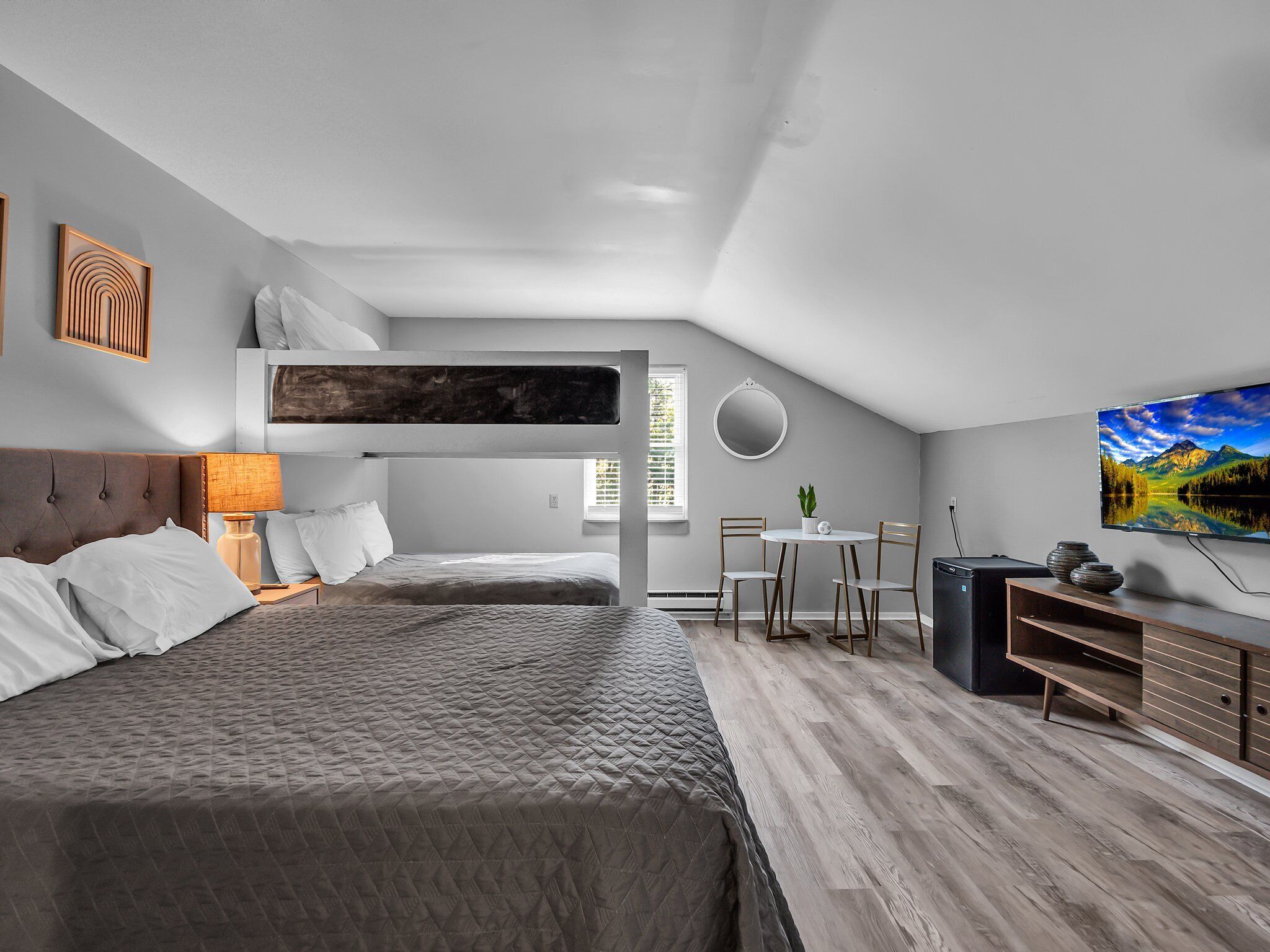 Un dormitorio moderno con una cama nido, un escritorio y una mesa de comedor.